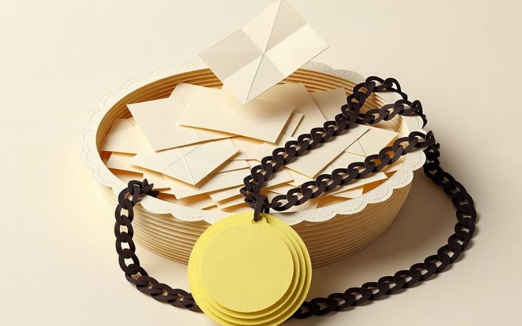Paper craft illustration of a jeweller counter with two separate kitty registers side by side, each with its own colour, slot cards and draw box